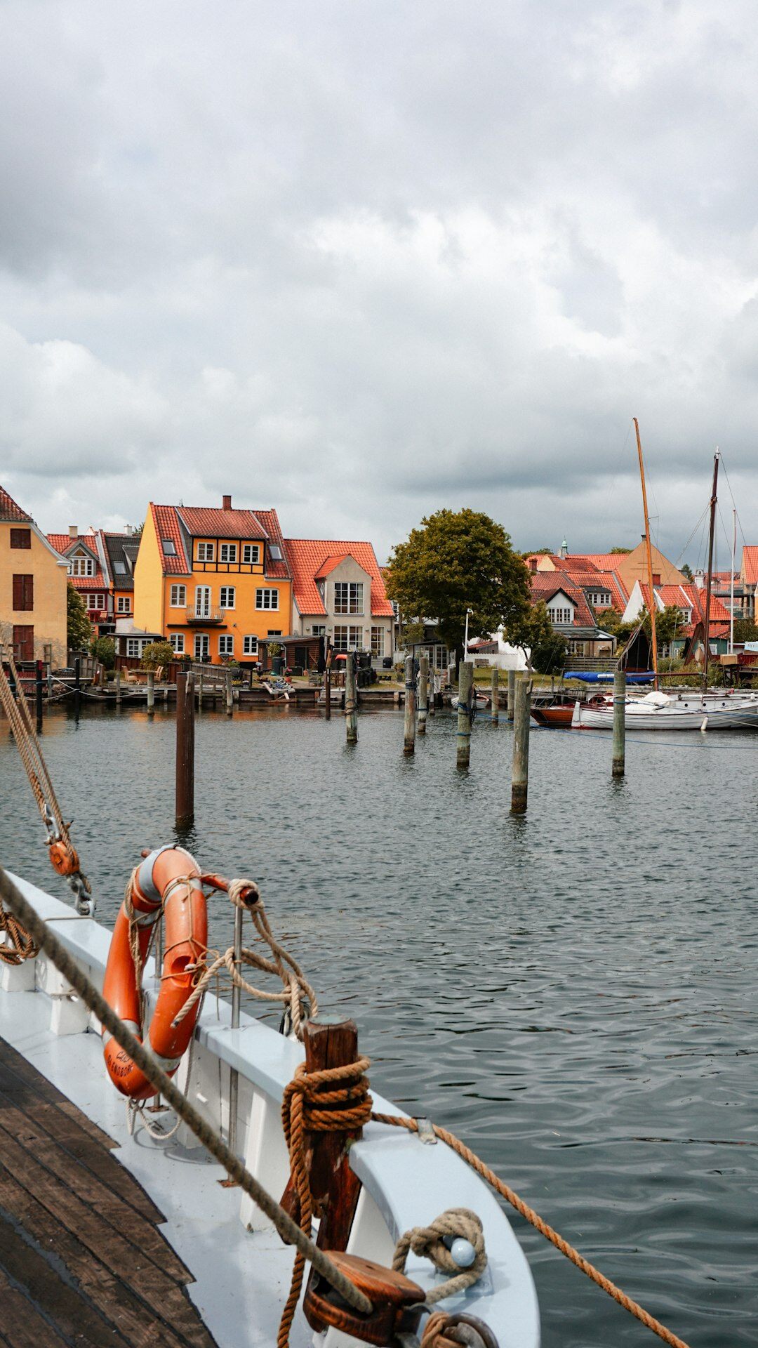 Documentary photo of a Danish fishing village at golden hour with wooden boats