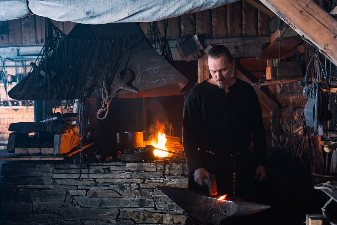 Danish blacksmith working at a forge in his workshop