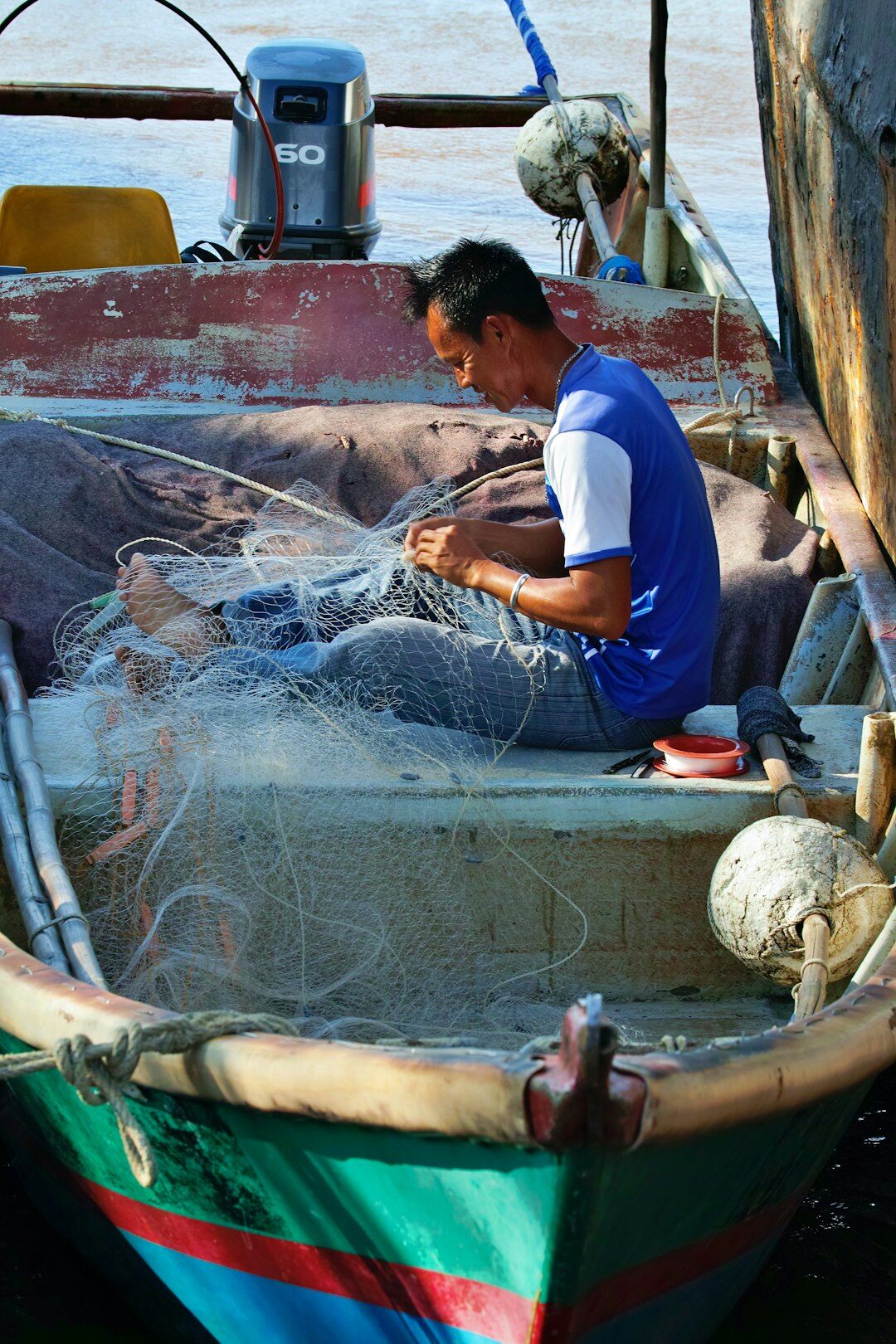 Danish fisherman mending nets on a boat deck